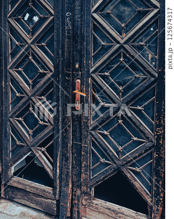 Double antique wooden doors with partially knocked out glass inserts. High quality photo 125674317