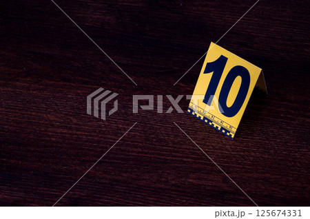 Yellow crime scene evidence marker number 10 on the floor in the room. High quality photo 125674331