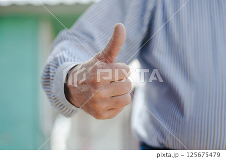 The shabby hands of a man with a finger up. The trembling hands of an old man show satisfaction. The shabby hands of a man with a finger up. The trembling hands of an old man show satisfaction. 125675479