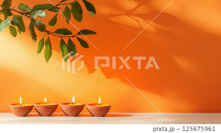 Four terracotta candles lit with leafy shadow on vibrant orange wall creating a peaceful atmosphere, AI Generative 125675961