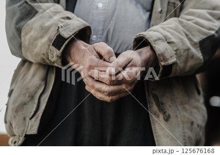 These hands have worked the land for decades. His old hands hold the weight of experience. 125676168