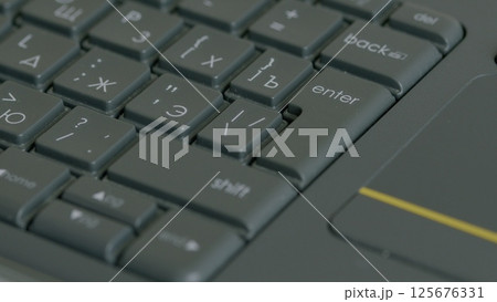 A closeup view of a laptop keyboard in action, showcasing the intricate design and functionality A closeup view of a laptop keyboard in action, showcasing the intricate design and functionality 125676331