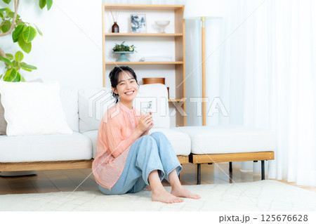 部屋でスマホを操作する若い女性 部屋でスマホを操作する若い女性 125676628