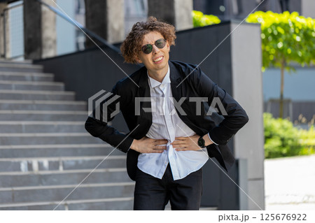 Sick businessman feels stomach pain standing on city street spasms, gastritis or poisoning Sick businessman feels stomach pain standing on city street spasms, gastritis or poisoning 125676922