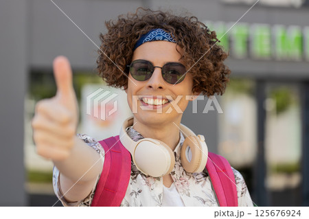 Happy young man tourist showing thumbs up like sign positive something good positive feedback Happy young man tourist showing thumbs up like sign positive something good positive feedback 125676924