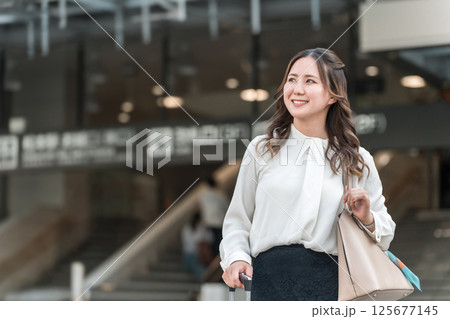 駅でスーツケースを持った出張・旅行帰りの女性・ビジネスウーマン 駅でスーツケースを持った出張・旅行帰りの女性・ビジネスウーマン 125677145