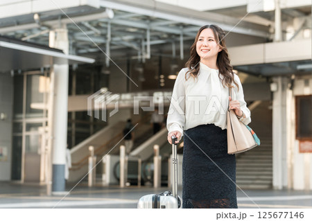 駅でスーツケースを持った出張・旅行帰りの女性・ビジネスウーマン 125677146