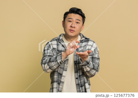Asian man show a little bit gesture begging help need some more please give me measuring small size 125677376