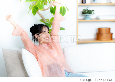 ソファでくつろぐ若い女性 ソファでくつろぐ若い女性 125678458