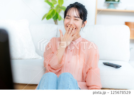 リビングでテレビを見る若い女性 リビングでテレビを見る若い女性 125678529