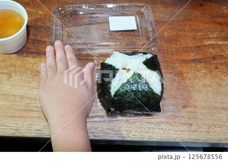 新潟駅で食べたとっても大きなジャンボおにぎり。おにぎりと子供の手のサイズ感。 125678556