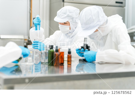 薬品工場,製薬会社で薬品開発をするクリーンスーツを着たスタッフ 薬品工場,製薬会社で薬品開発をするクリーンスーツを着たスタッフ 125678562