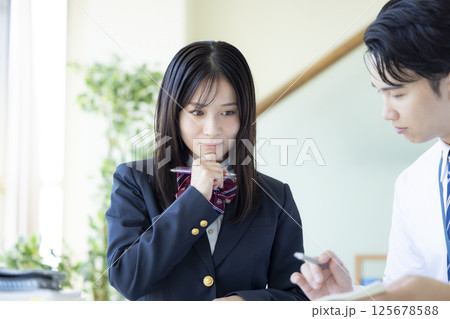 塾で勉強する高校生と講師 125678588