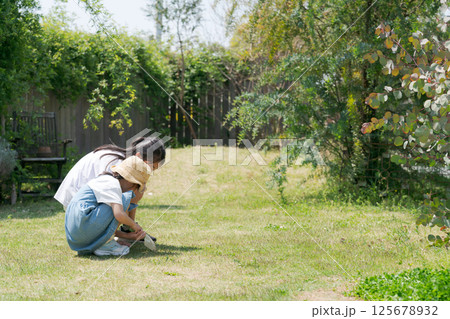 芝生に座って遊ぶ女の子 125678932