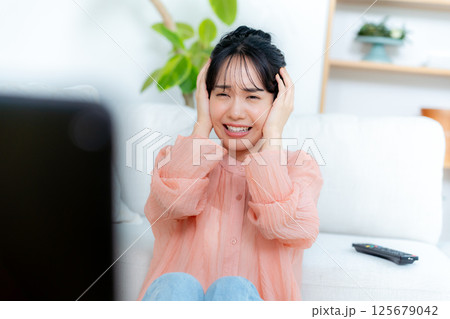 リビングでテレビを見る若い女性 125679042