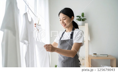 洗濯物を干す日本人女性 125679043