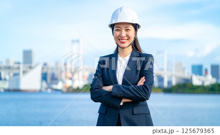 ヘルメットを装着して作業着を着た日本人女性 125679365