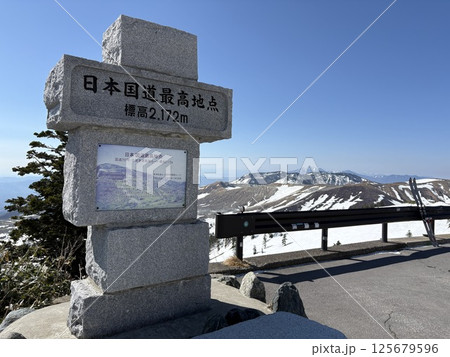 夏期の道路開通直後の日本国道最高地点の石碑_残雪の渋峠 125679596