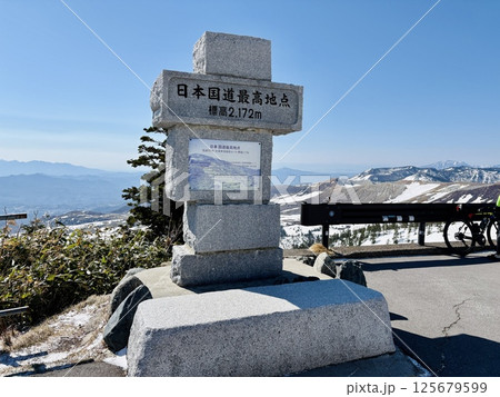 夏期の道路開通直後の日本国道最高地点の石碑_残雪の渋峠 125679599