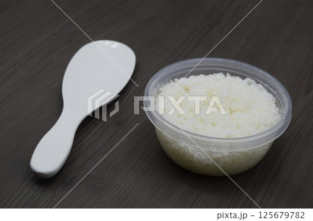 しゃもじと保存容器に入った白米 125679782