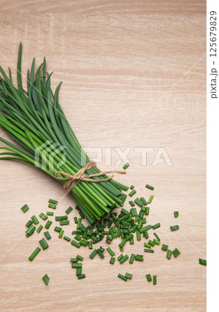 Freshly cut chives tied with twine on wooden table 125679829
