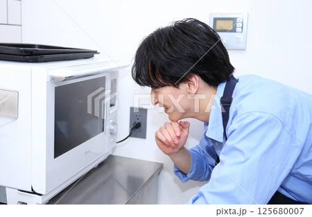 男性のキッチン 電子レンジを使用するイメージ 男性のキッチン 電子レンジを使用するイメージ 125680007