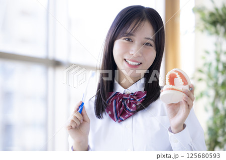 デンタルケア　歯磨きをする女子高生 125680593
