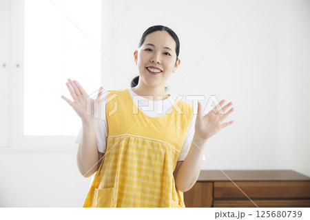 黄色いエプロンのミドル女性 125680739