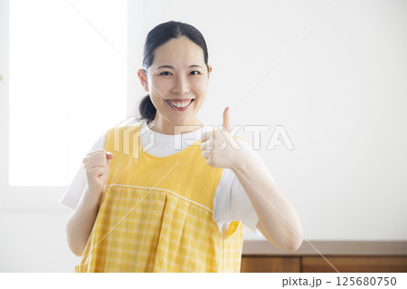 黄色いエプロンのミドル女性 125680750