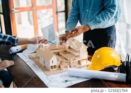 Two architects discussing new project. young men and women working together to form a new building. Two architects discussing new project. young men and women working together to form a new building. 125681764