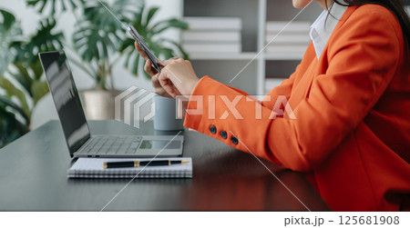 Businesswoman hand using laptop, tablet and smartphone in office. Digital marketing media mobile app and discussing plan new start up project. Finance task. Businesswoman hand using laptop, tablet and smartphone in office. Digital marketing media mobile app and discussing plan new start up project. Finance task. 125681908
