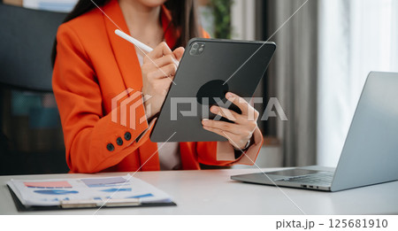 Businesswoman hand using laptop, tablet and smartphone. Digital marketing media mobile app and discussing plan new start up project. Finance task. 125681910