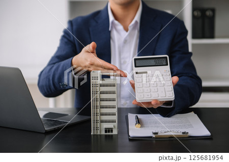 Real estate broker agent presenting to customer to decision making sign insurance form agreement, buy and sell home model, concerning mortgage loan offer Real estate broker agent presenting to customer to decision making sign insurance form agreement, buy and sell home model, concerning mortgage loan offer 125681954