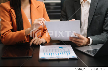 Businessman and team analyzing financial statement Finance task. with smart phone and laptop and  tablet. Wealth management concept 125681967