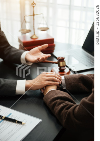Judge gavel with scales of justice, Business and lawyer or counselor consulting and discussing contract papers with laptop and tablet at law firm 125682026