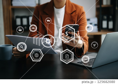 Businesswoman hand using laptop, tablet and smartphone  in office. Digital marketing media mobile app in virtual icon 125682080