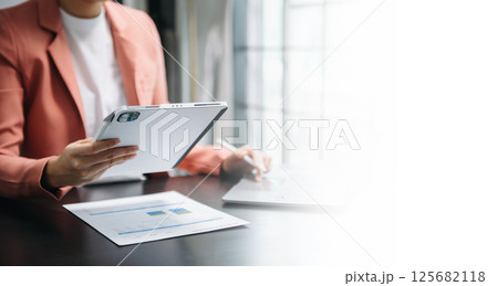 Businesswoman hand using laptop, tablet and smartphone in office. Digital marketing media mobile app and discussing plan new start up project. Finance task. 125682118