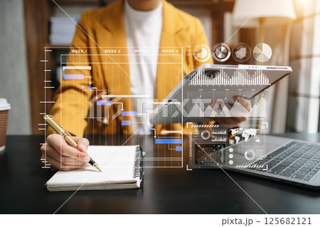 Businessman hand Project manager working and update tasks and Gantt chart scheduling virtual diagram.with smart phone, tablet and laptop 125682121