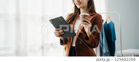 Young woman running online store Startup small business SME, using smartphone or tablet receive and checking online purchase shopping order 125682208
