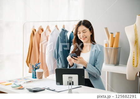 Diverse female fashion designers at work with tailor centimeters on necks and holds tablet and smartphone. independent creative design 125682291