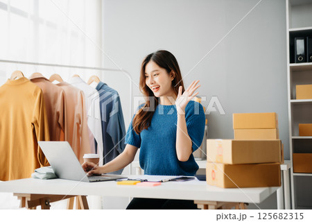 Asian lady blogger showing clothes in front of the camera to recording vlog video live streaming at her shop. Online Shopping Asian lady blogger showing clothes in front of the camera to recording vlog video live streaming at her shop. Online Shopping 125682315