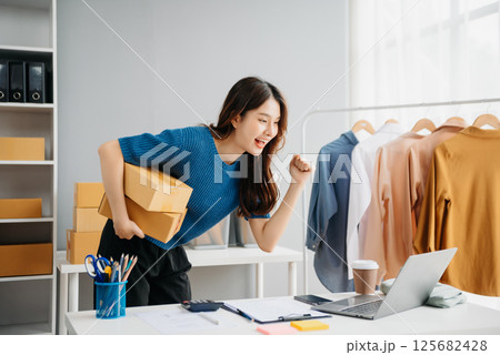 Startup small business SME, Entrepreneur owner woman using smartphone or tablet taking receive and checking online purchase shopping order 125682428