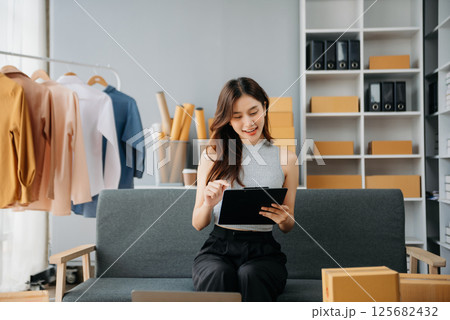 Young woman running online store Startup small business SME, using smartphone or tablet taking receive and checking online purchase shopping Young woman running online store Startup small business SME, using smartphone or tablet taking receive and checking online purchase shopping 125682432