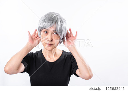 聞き耳を立てる白髪シニア女性 125682443