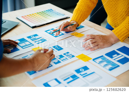 View of UI developer team brainstorming on their project with laptop, smartphone and digital tablet. Creative digital development agency. 125682620