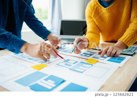 View of UI developer team brainstorming on their project with laptop, smartphone and digital tablet. Creative digital development agency. 125682621