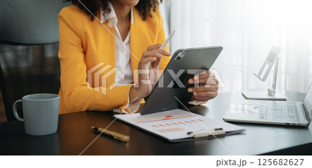 African businesswoman hand working with new modern computer using on smartphone and tablet as concept African businesswoman hand working with new modern computer using on smartphone and tablet as concept 125682627