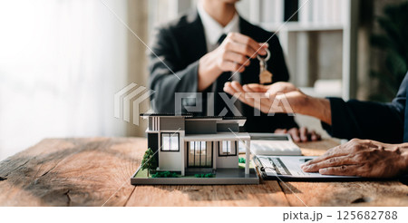 Signing a contract. Client and broker agent, lease agreement, successful deal and  Young business sitting at the desk in office 125682788