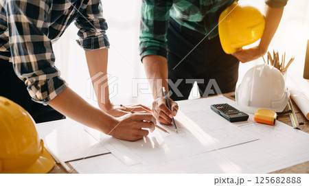 Two colleagues discussing data working and tablet, laptop with on on architectural project at construction site Two colleagues discussing data working and tablet, laptop with on on architectural project at construction site 125682888