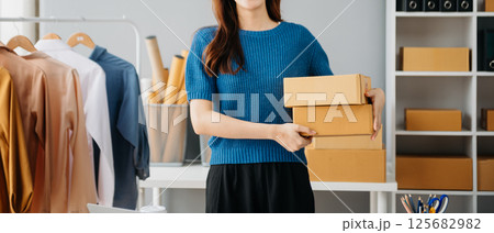 Young woman running online store Startup small business SME, using smartphone or tablet taking receive and checking online purchase shopping Young woman running online store Startup small business SME, using smartphone or tablet taking receive and checking online purchase shopping 125682982